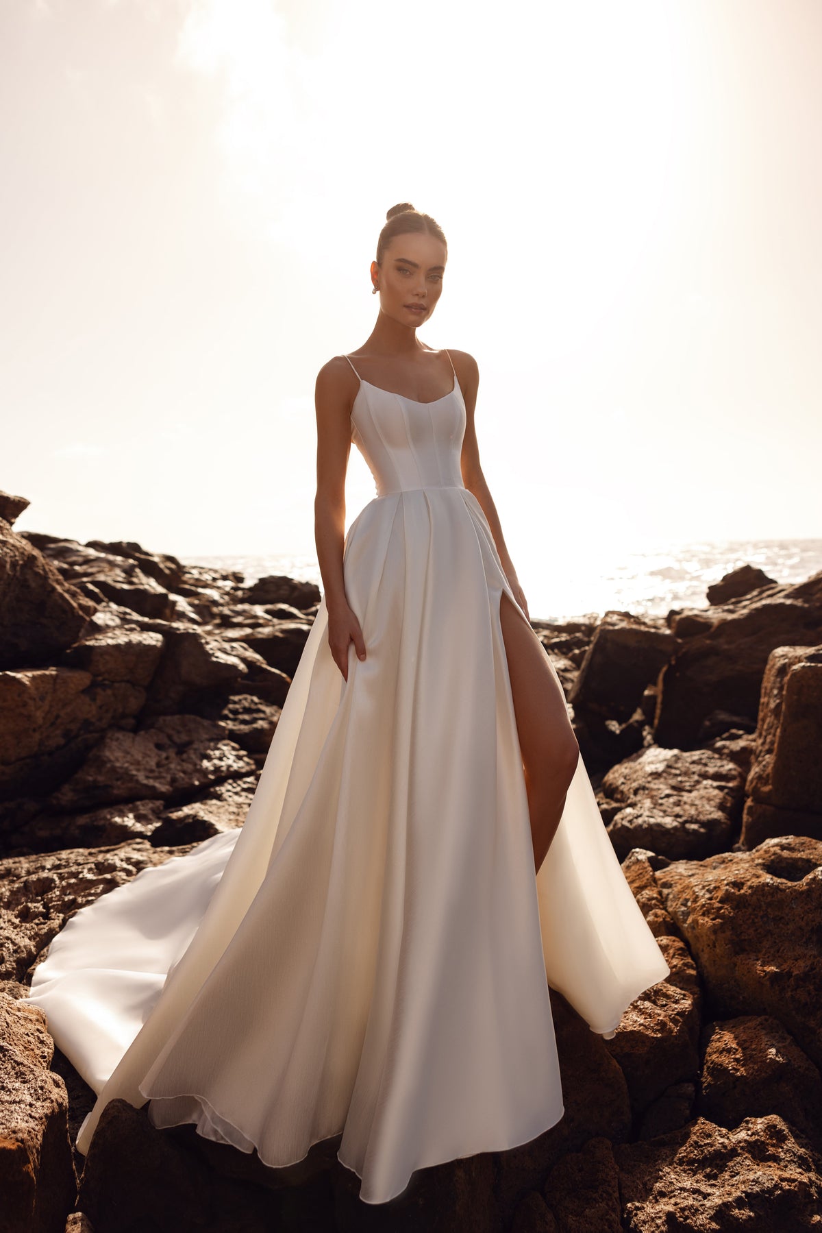 Abito da sposa Alya in raso opaco, con corpetto a corsetto e spalline sottili: un’eleganza essenziale vista di fronte.