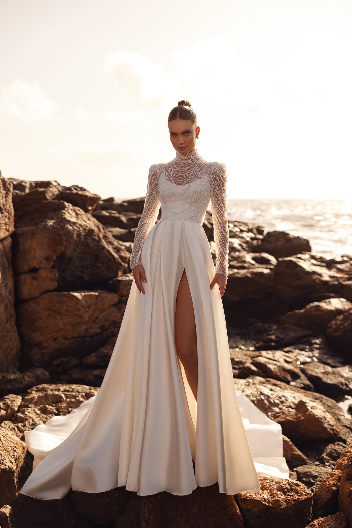 L’alto spacco laterale di Alya alleggerisce la linea e mette in risalto la gamba, per un look da sposa deciso e aggraziato.