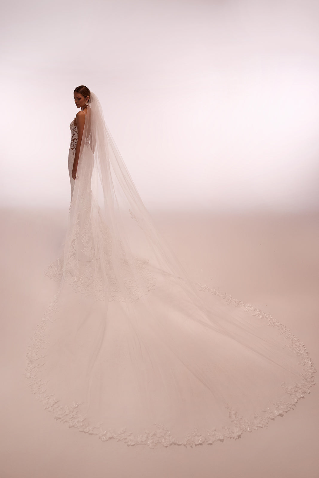 Velo da sposa lungo e classico Apolonia, bordato di pizzo floreale e con pettinino di fissaggio, dell’atelier di abiti da sposa Dama Couture (vista posteriore)