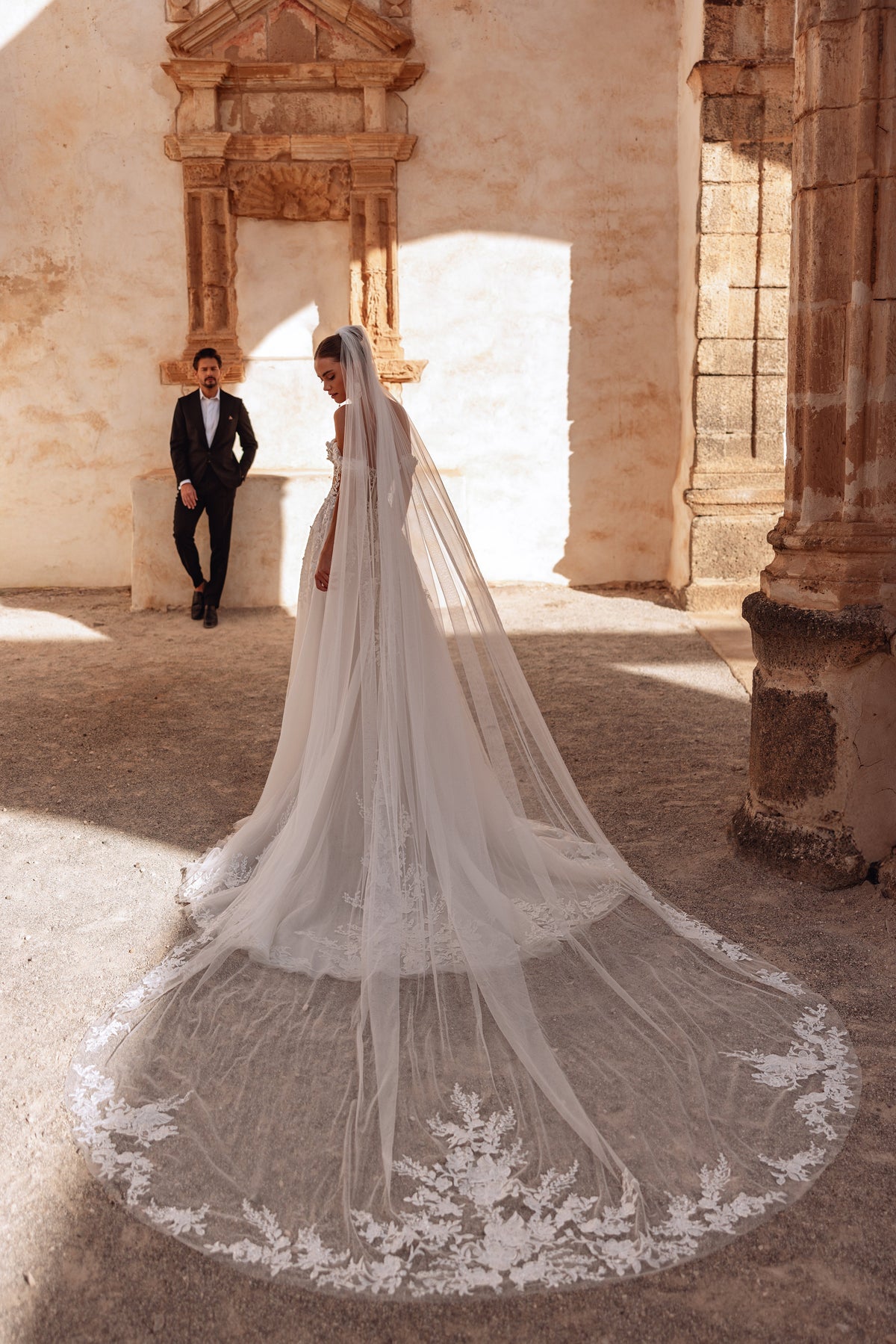 Il velo da sposa cattedrale Ariella, bordato di pizzo, aggiunge un accento scenografico e senza tempo, per cerimonie eleganti.