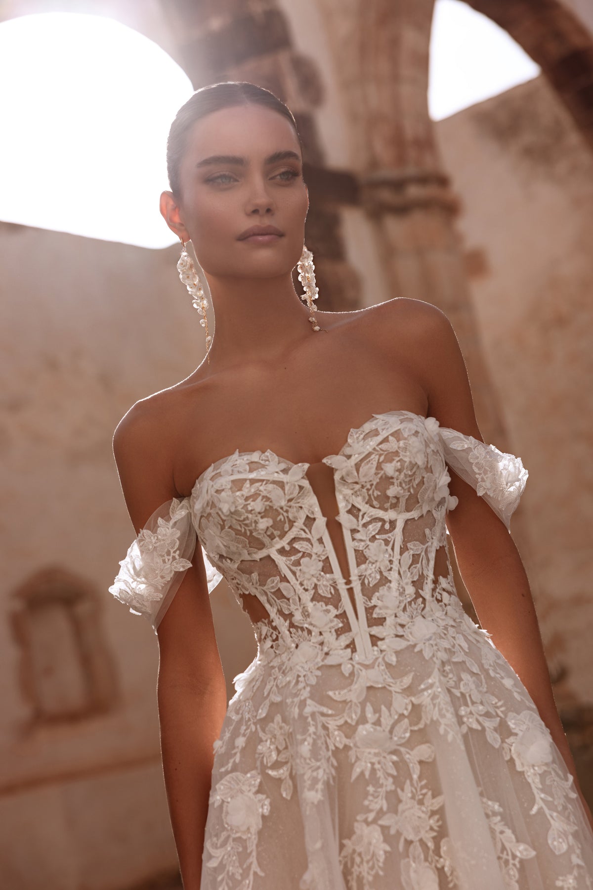 Il dettaglio del corsetto Ariella mostra i motivi floreali in pizzo applicati con cura, che sottolineano l’eleganza romantica dell’abito.