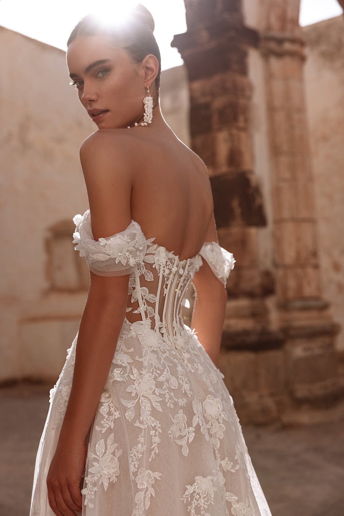 Le maniche in tulle di Ariella lasciano scoperte le spalle e aggiungono all’abito leggerezza e un delicato carattere romantico.