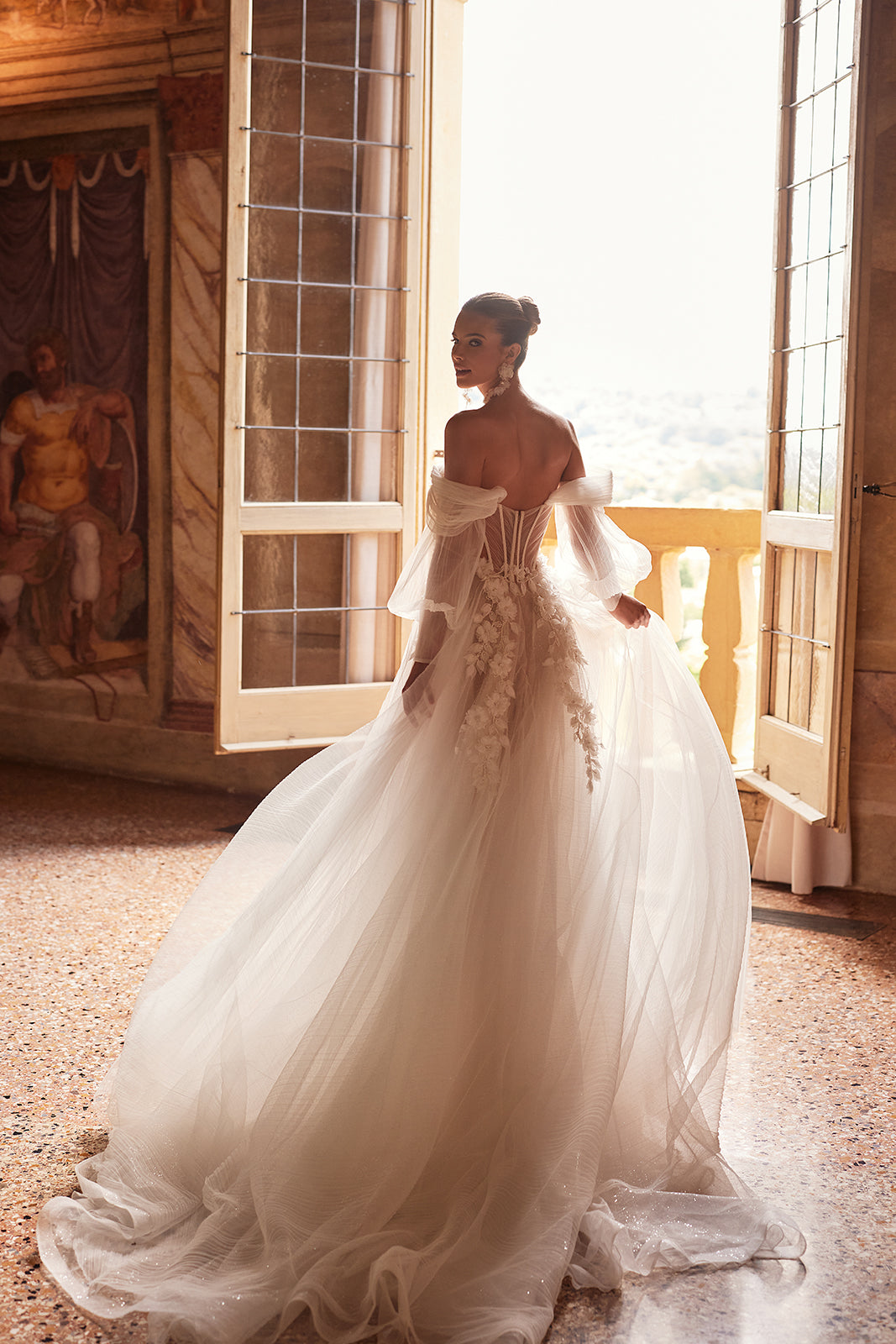 Abito da sposa a principessa Avalon con maniche che scendono dalle spalle di DAMA Couture (foto della campagna)