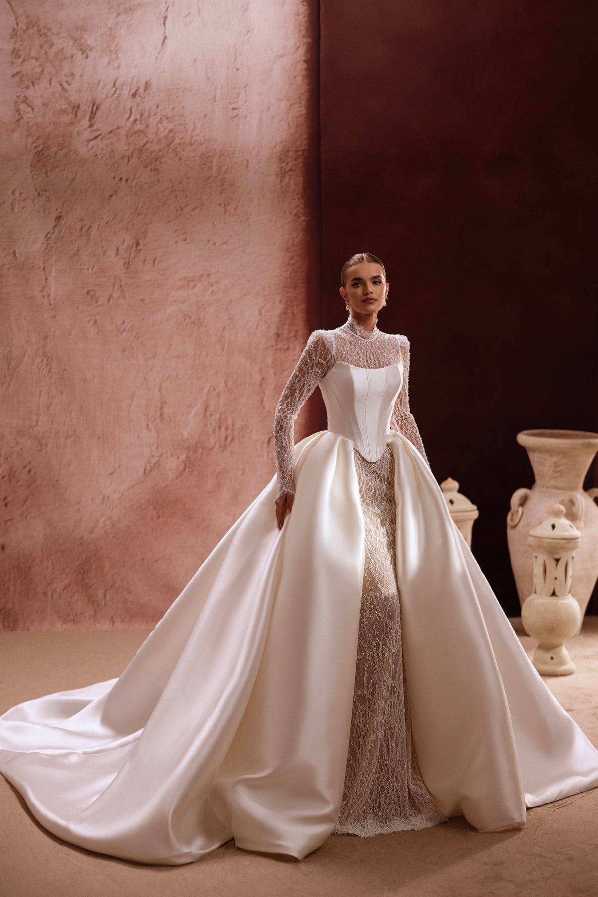 La sopragonna Henriette presenta dettagli scintillanti in pizzo e uno strascico in raso, per un abito da sposa contemporaneo e prezioso.