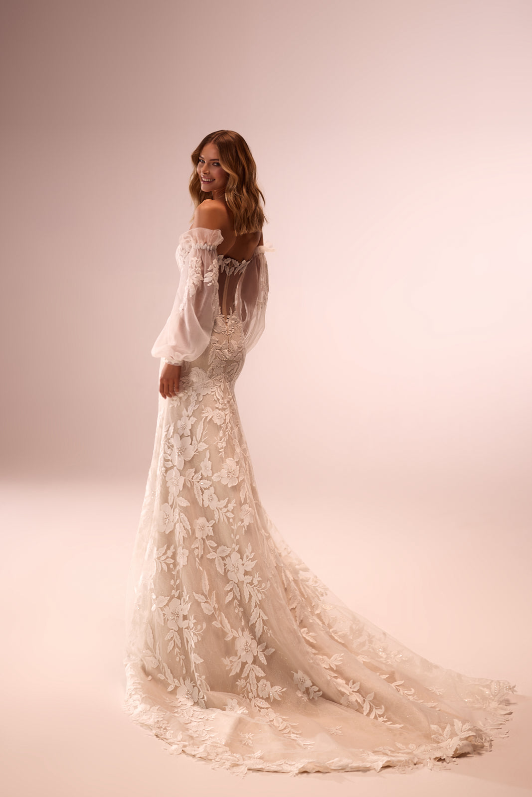 Abito da sposa romantico Lucrezia con maniche che scendono dalle spalle di DAMA Couture (vista posteriore in studio)