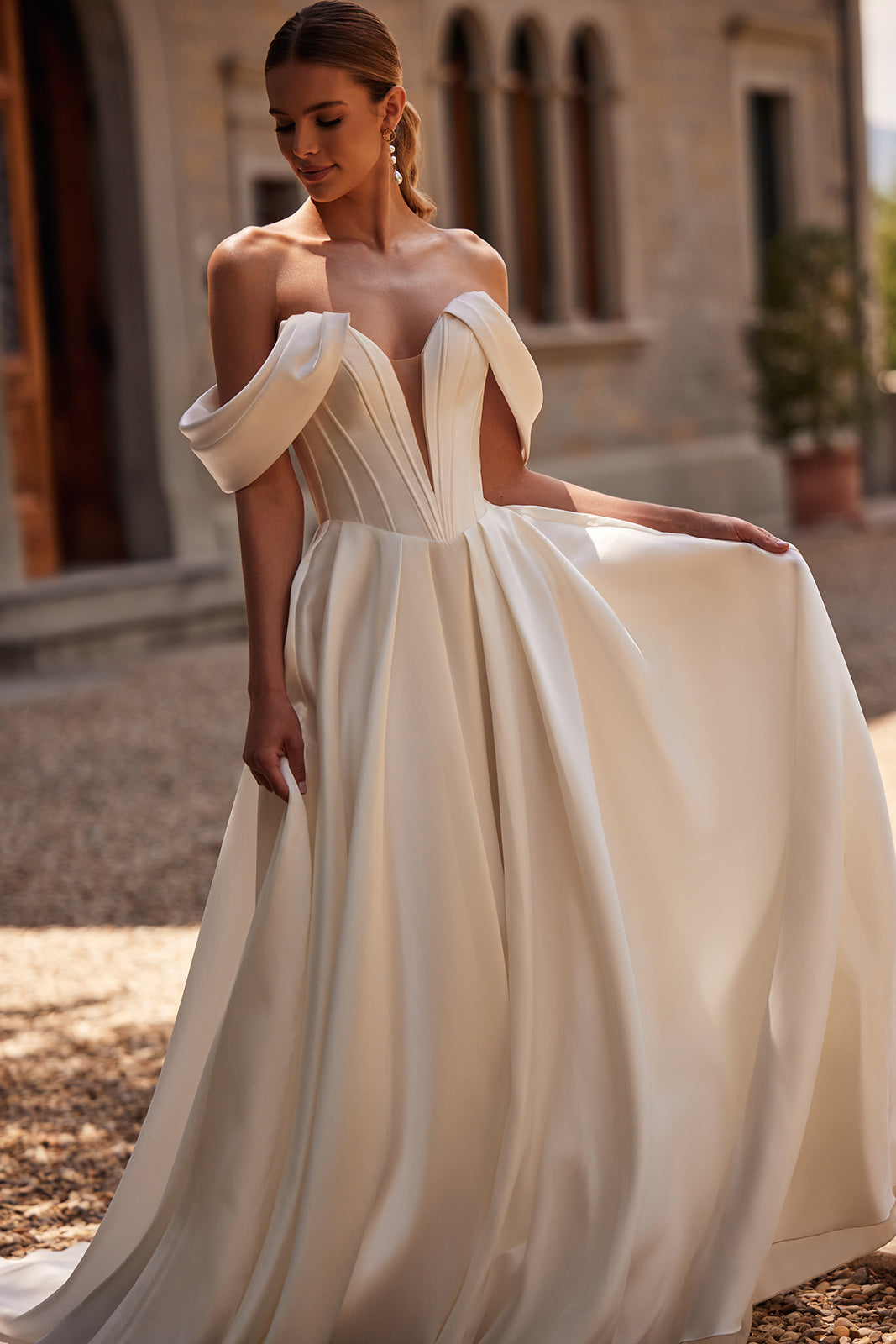 Abito da sposa Thalia classico ed essenziale, con maniche che scendono dalle spalle, di DAMA Couture (vista frontale)