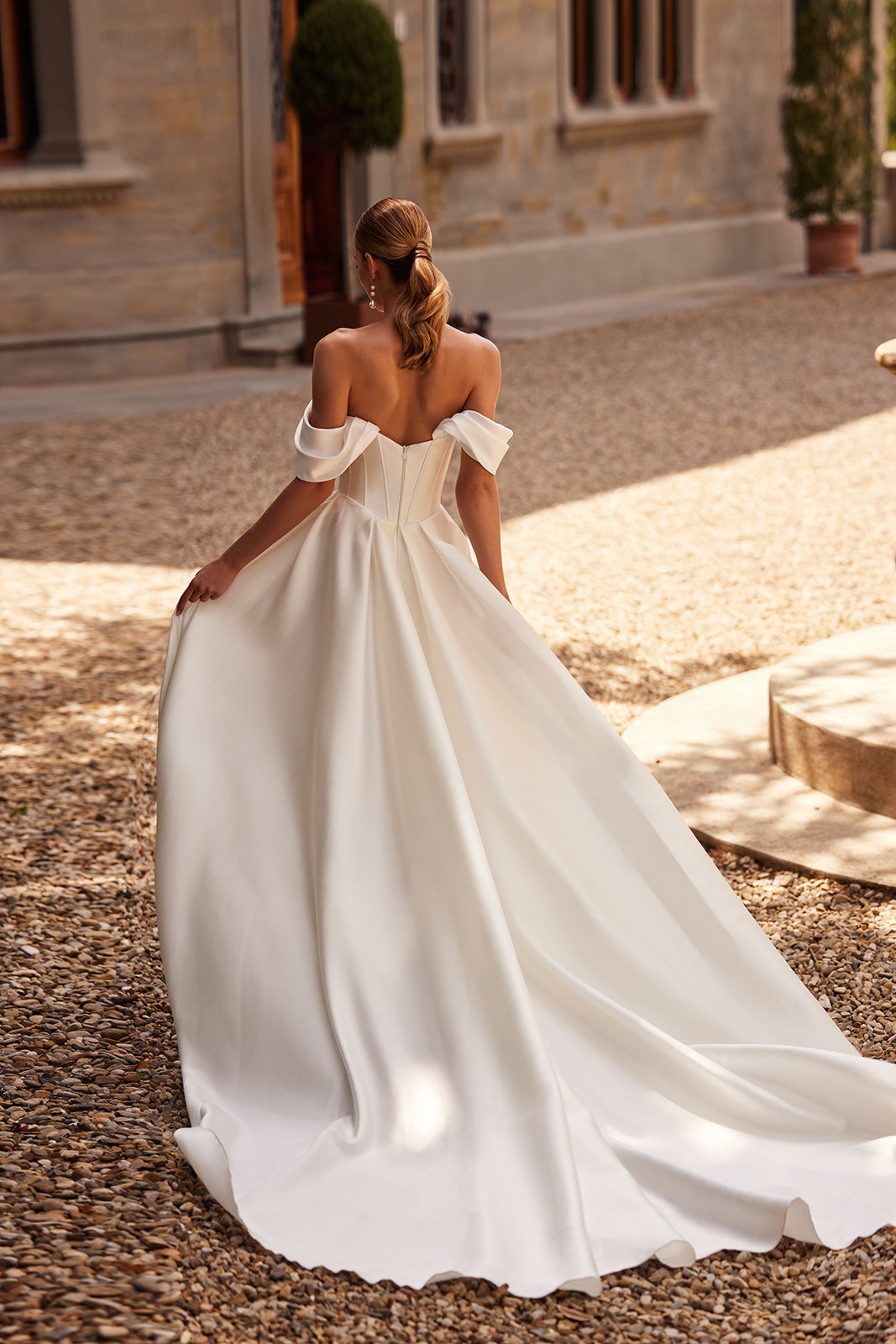 Abito da sposa Thalia classico ed essenziale, con maniche che scendono dalle spalle, di DAMA Couture (seconda vista posteriore)