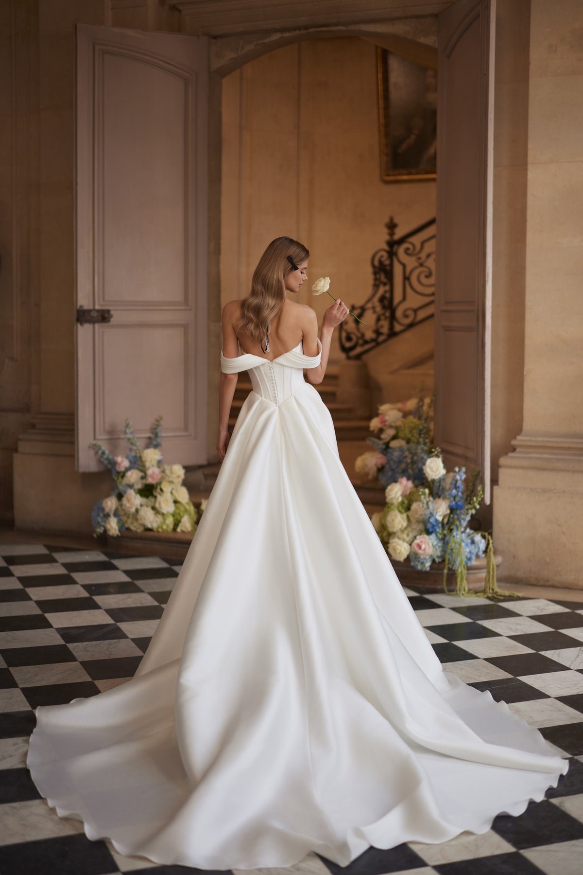 Abito da sposa Alienor – maniche drappeggiate che lasciano le spalle scoperte e una gonna in raso dalle linee essenziali.