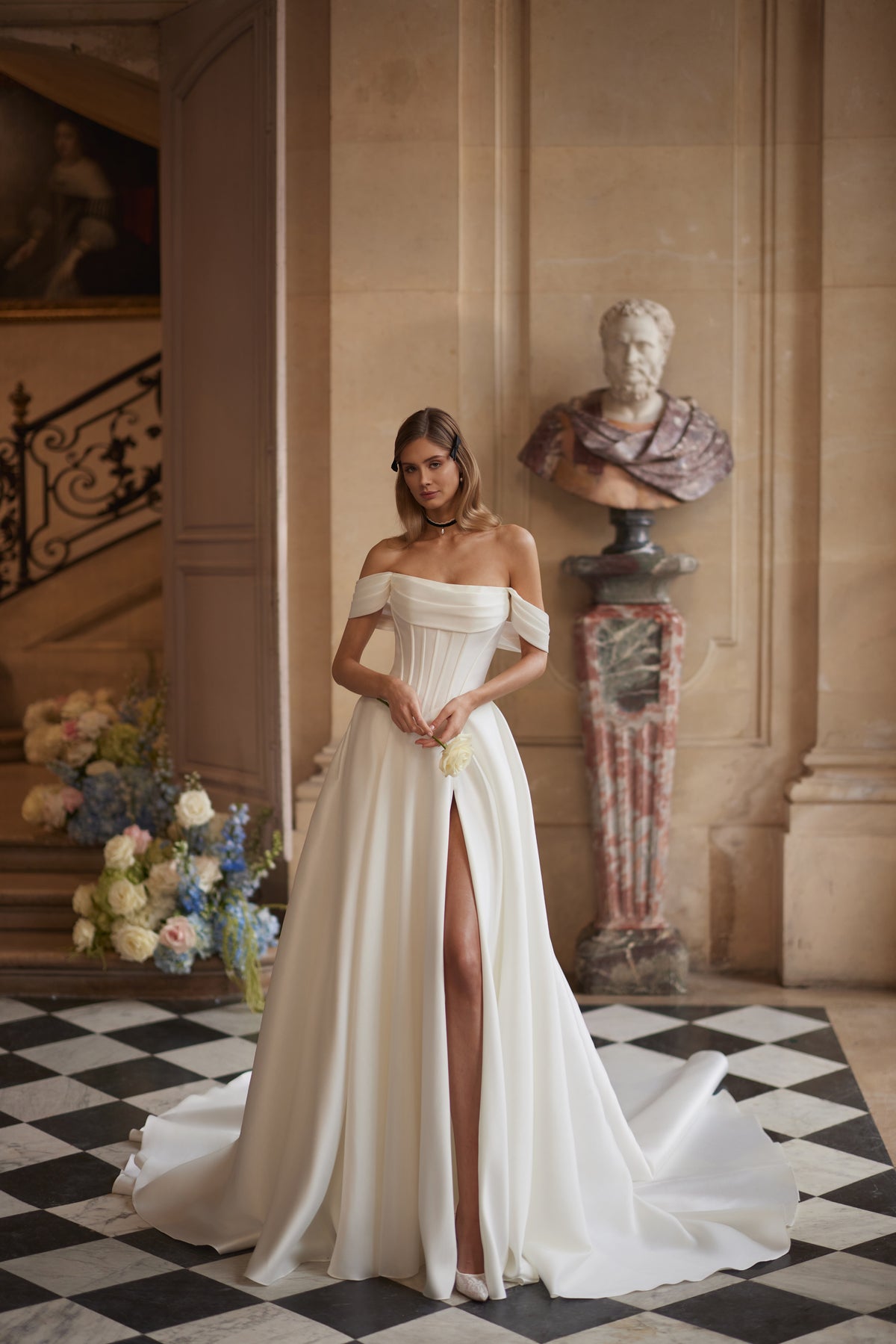 Abito da sposa Alienor – maniche drappeggiate che lasciano le spalle scoperte e una gonna in raso dalle linee essenziali, DAMA Couture Something Blue 2027.