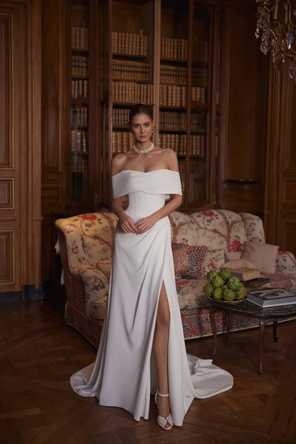 Abito da sposa Calliope – abito da sposa a trapezio con un ampio scollo che lascia le spalle scoperte e una gonna in raso dalle linee essenziali con spacco.