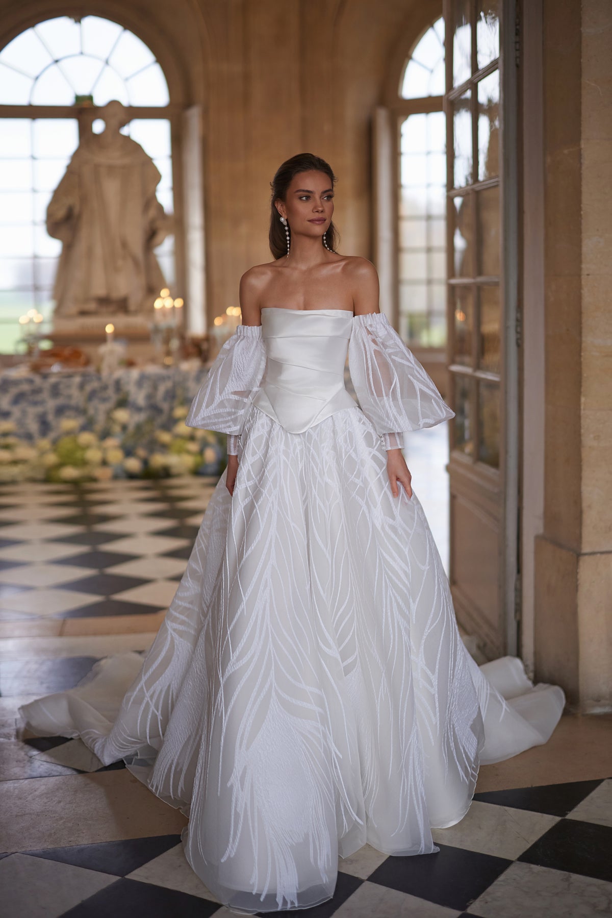 Corsetto Charlize della collezione Something Blue 2027 – un corsetto senza spalline dalle linee essenziali, abbinato a voluminose maniche che lasciano le spalle scoperte.