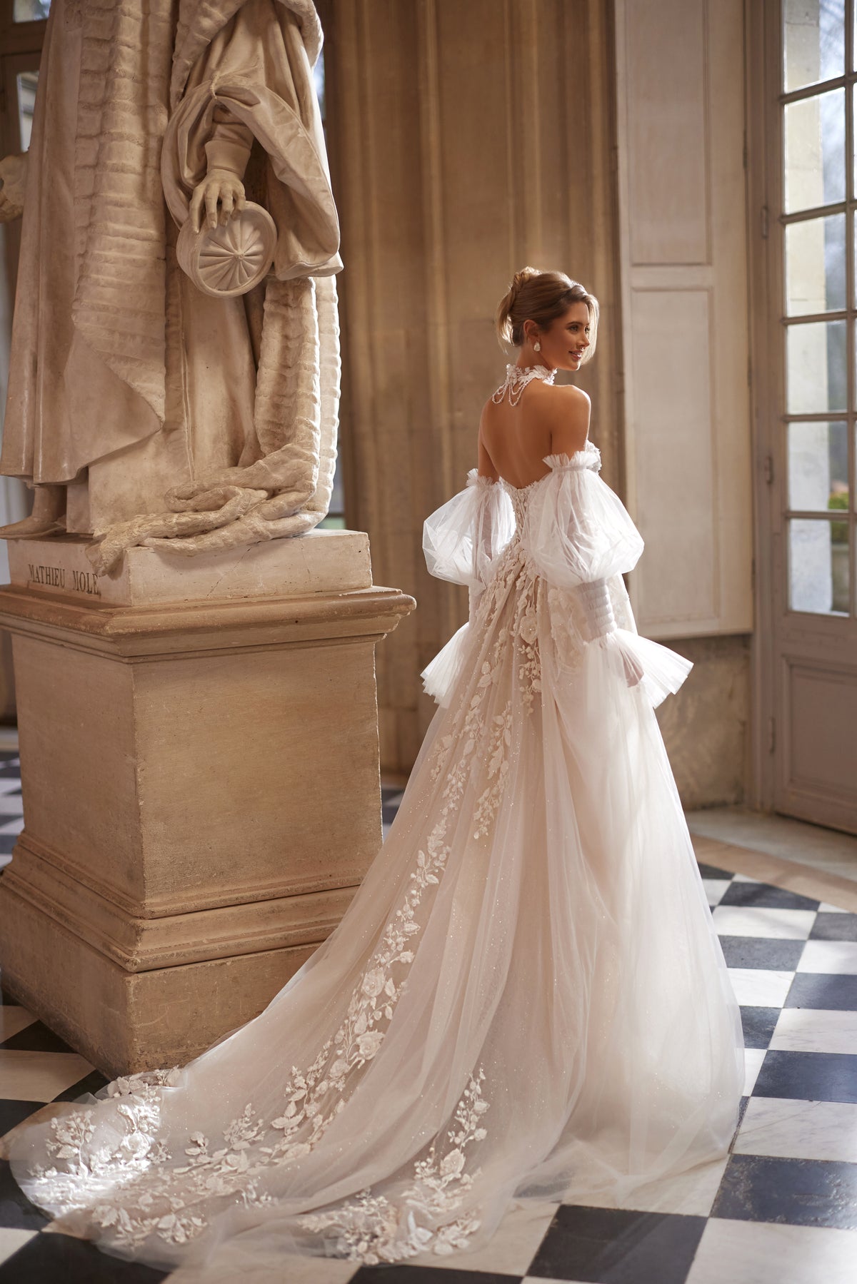 Abito da sposa Estella della collezione Something Blue 2027 – un corsetto con fiori in rilievo e voluminose maniche che lasciano le spalle scoperte.