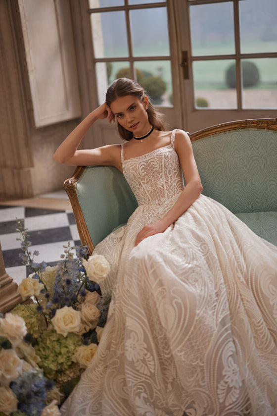 Abito da sposa Frigga – abito da sposa a trapezio con spalline sottili, uno scollo quadrato e un’ampia gonna da ballo in pizzo grafico.