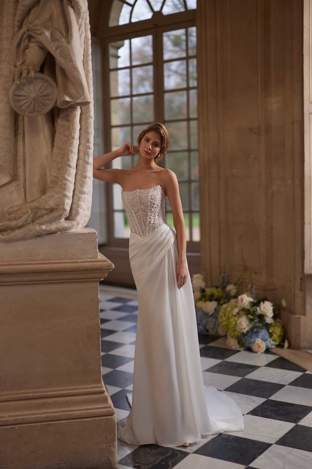 Abito da sposa Greta – abito da sposa a sirena con un corsetto senza spalline riccamente decorato di perline e una gonna drappeggiata in raso.