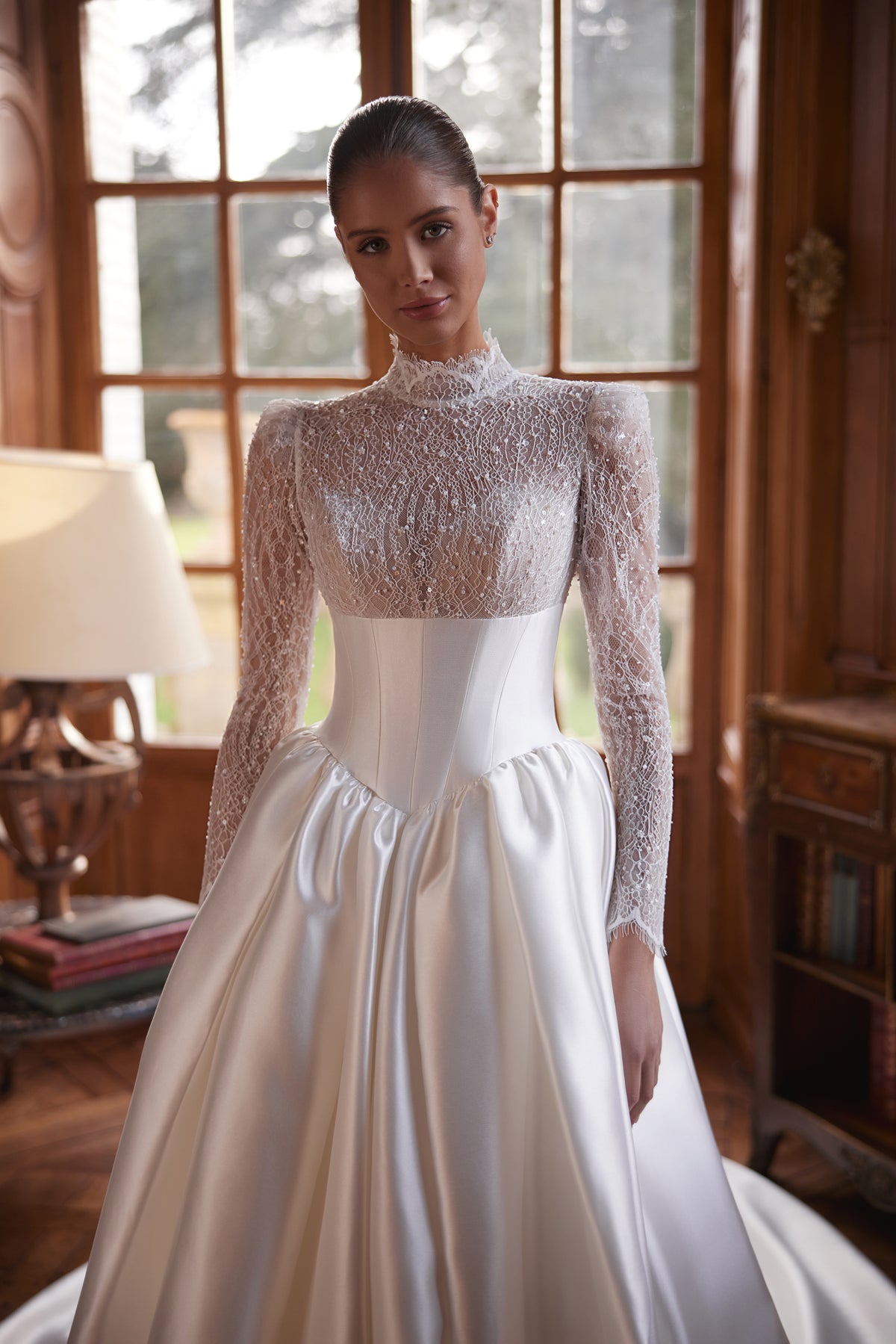 Abito da sposa Maristella – abito da sposa a trapezio con un corpetto in pizzo a collo alto con maniche lunghe e un’ampia gonna in raso.