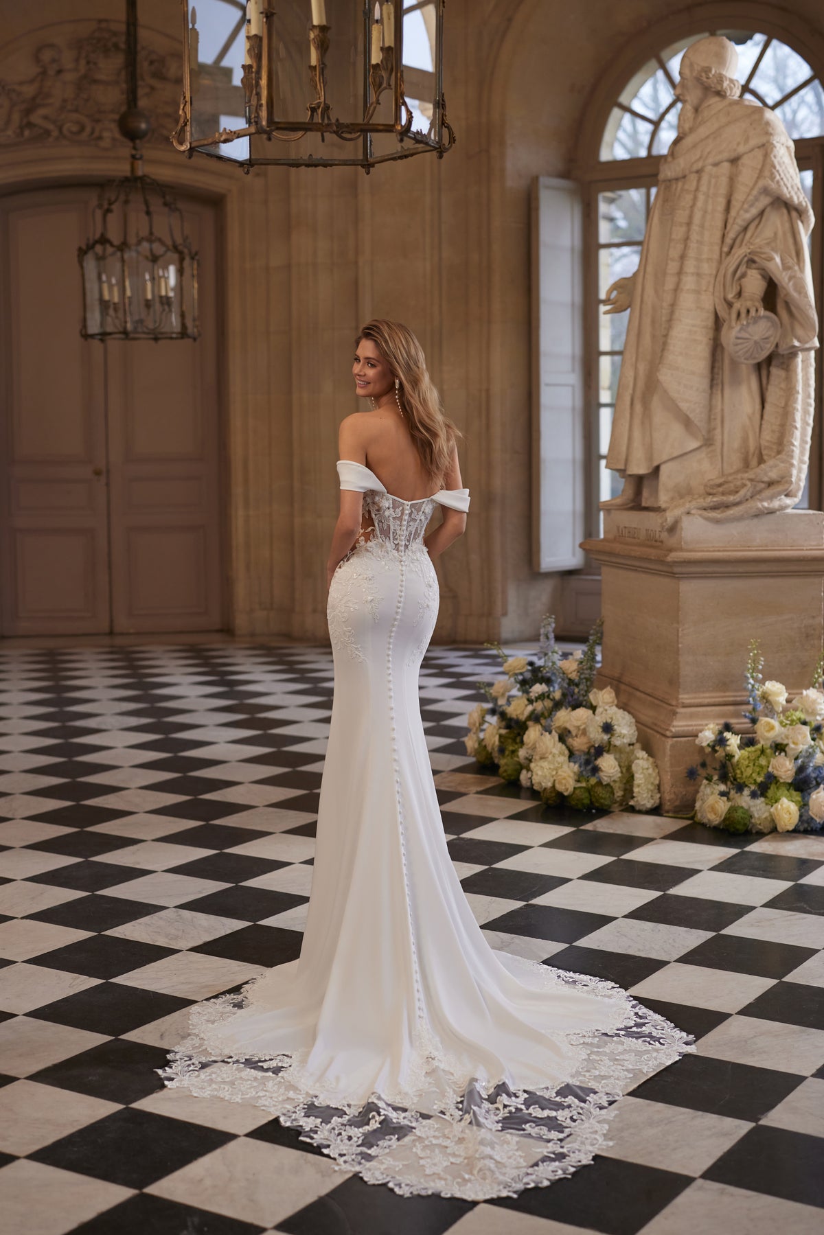 Abito da sposa Matilde – uno scollo che lascia le spalle scoperte e una silhouette aderente disegnata dal pizzo.