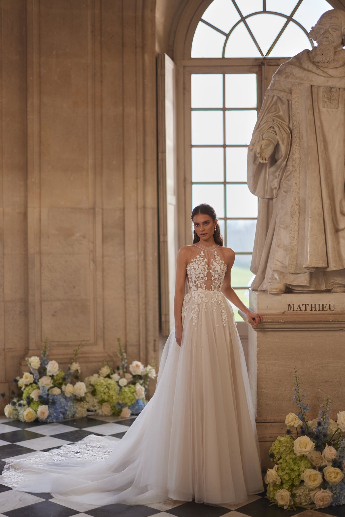 Abito da sposa Nilla della collezione Something Blue 2027 – un collo alto trasparente e una gonna in tulle con pizzo floreale.