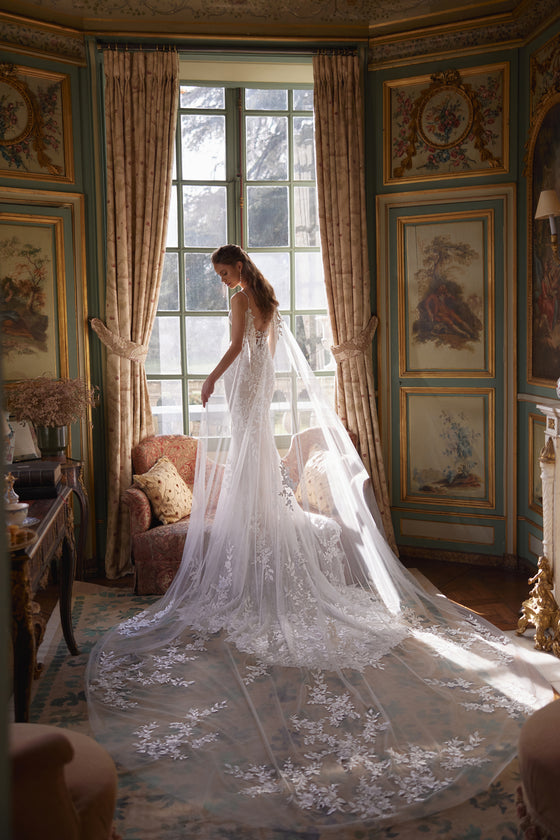Mantella Ondine: mantella da sposa trasparente che ricade dalle spalle, indossata sopra l’abito da sposa Ondine.