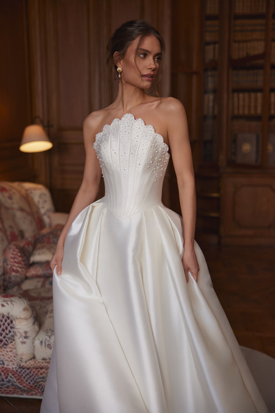 Abito da sposa Shella – abito da sposa a trapezio con un corsetto scolpito senza spalline e un’ampia gonna in raso.