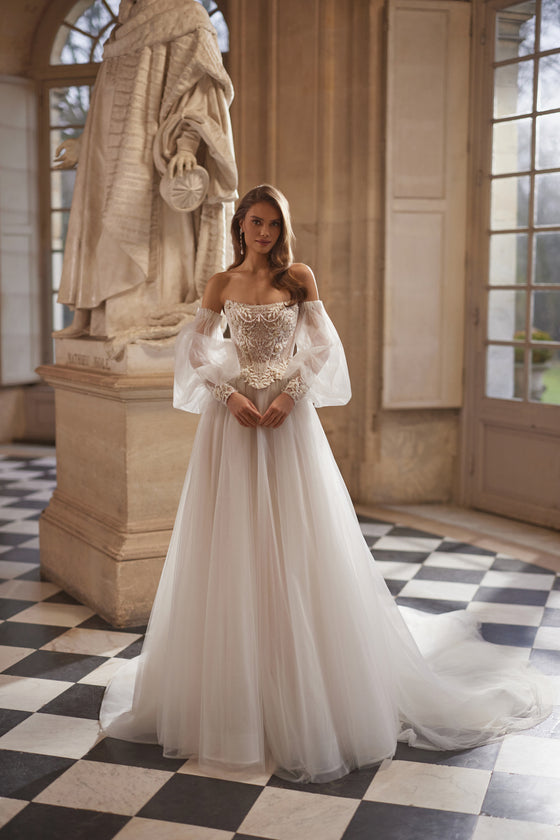 Corsetto Tara + gonna a trapezio Tilda – abito da sposa a trapezio con un corsetto strutturato Tara con maniche che lasciano le spalle scoperte e la gonna a trapezio Tilda.