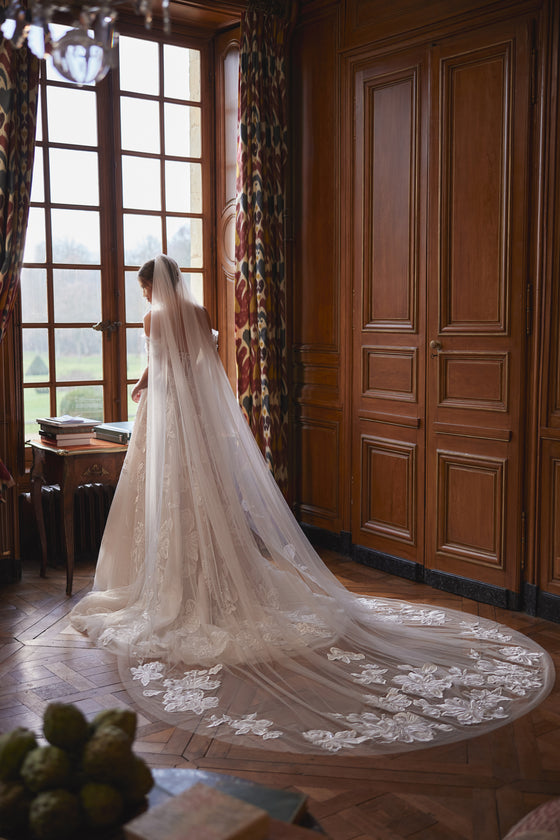 Velo Vespera: lungo velo in tulle con ricami floreali, indossato con l’abito da sposa Vespera.