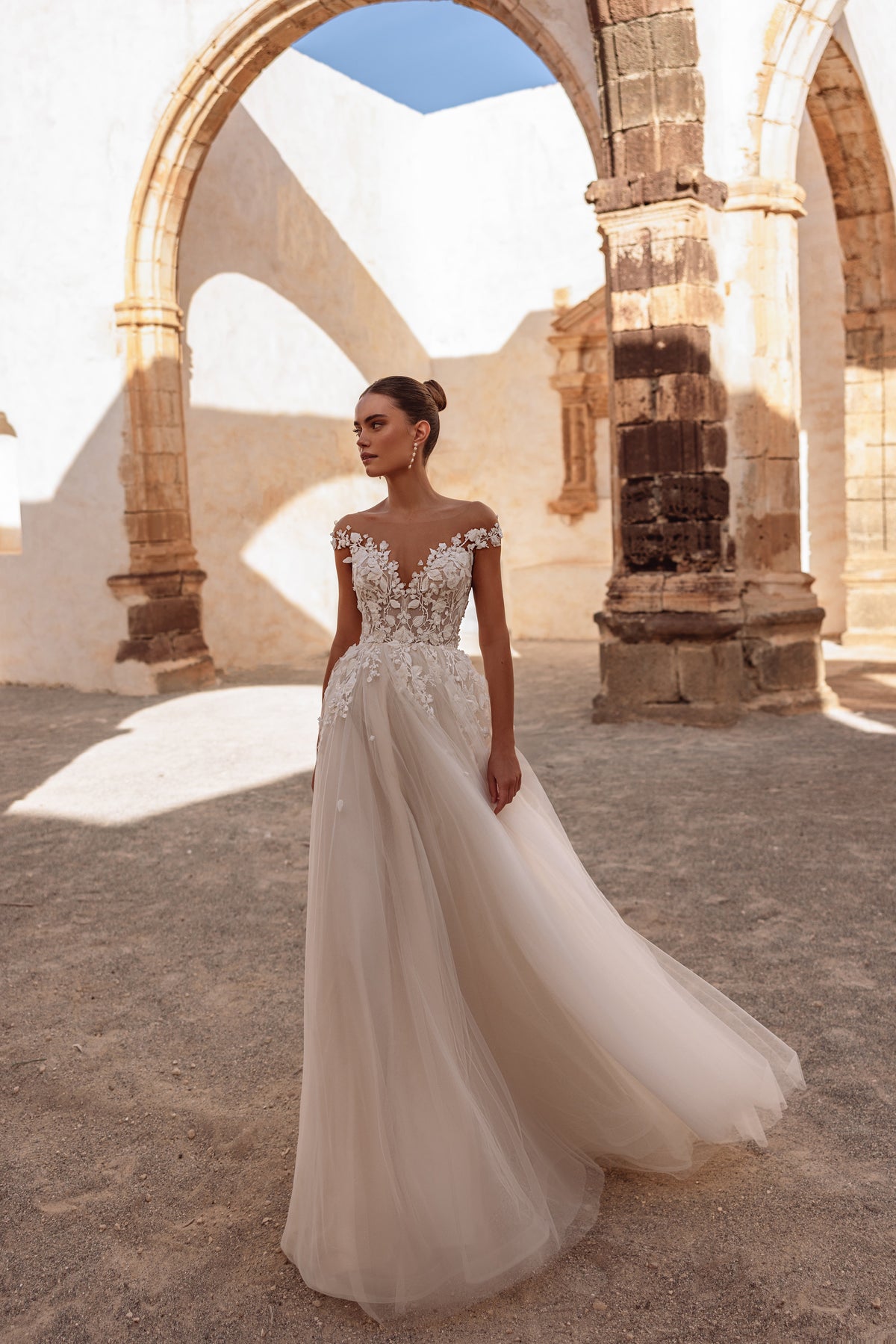 L’abito da sposa Andrea, con corpetto in pizzo a spalle scoperte e gonna leggera in tulle, esprime un’eleganza delicata.