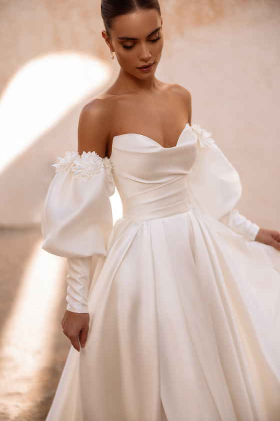 Il retro dell’abito da sposa Anika in raso valorizza la figura con pieghe morbide ed eleganza essenziale.