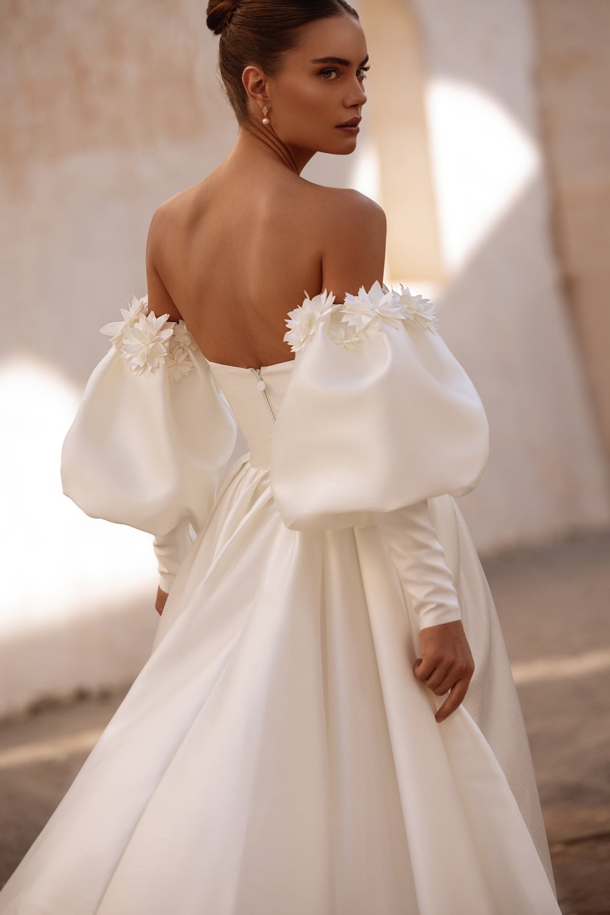 Abito da sposa Anika dal romanticismo contemporaneo, con lunghe maniche a sbuffo e dettagli floreali, per un look personale.