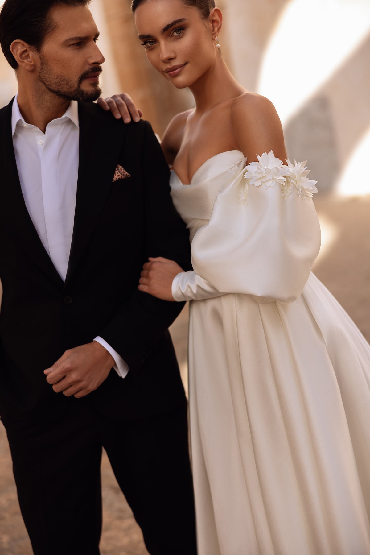 Romantico abito da sposa Anika in raso, con scollo a cuore e gonna voluminosa illuminata dalla luce naturale del sole.