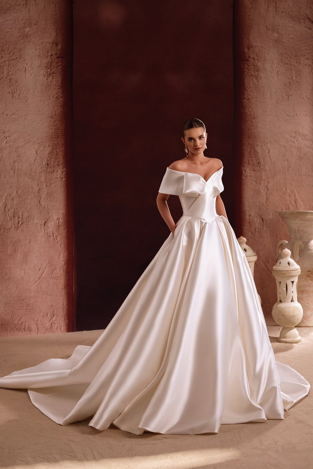Il corpetto in raso a spalle scoperte dell’abito da sposa Avin mette in risalto il disegno scultoreo e l’eleganza contemporanea.