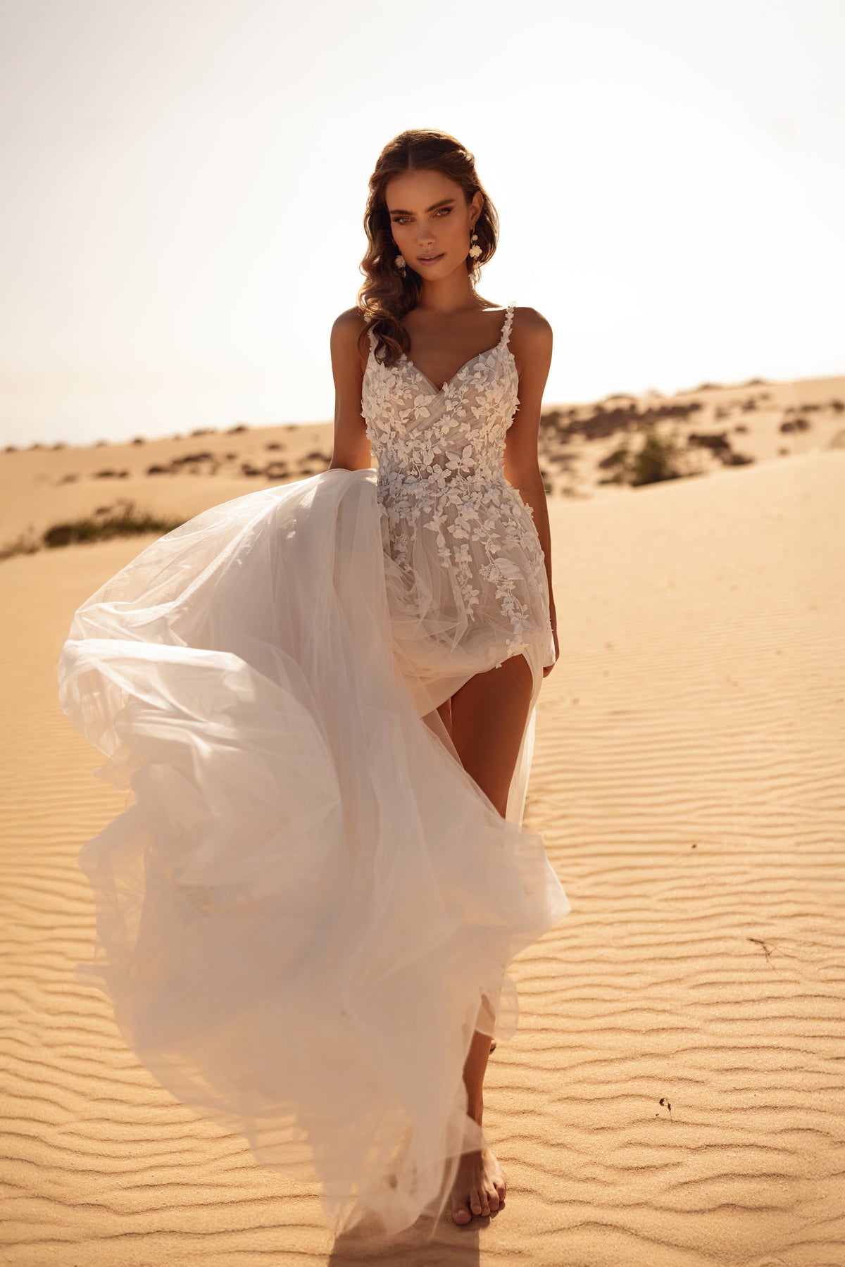 L’abito da sposa Aviva, con scollo profondo e spalline in pizzo, unisce una sensualità delicata alla raffinatezza.