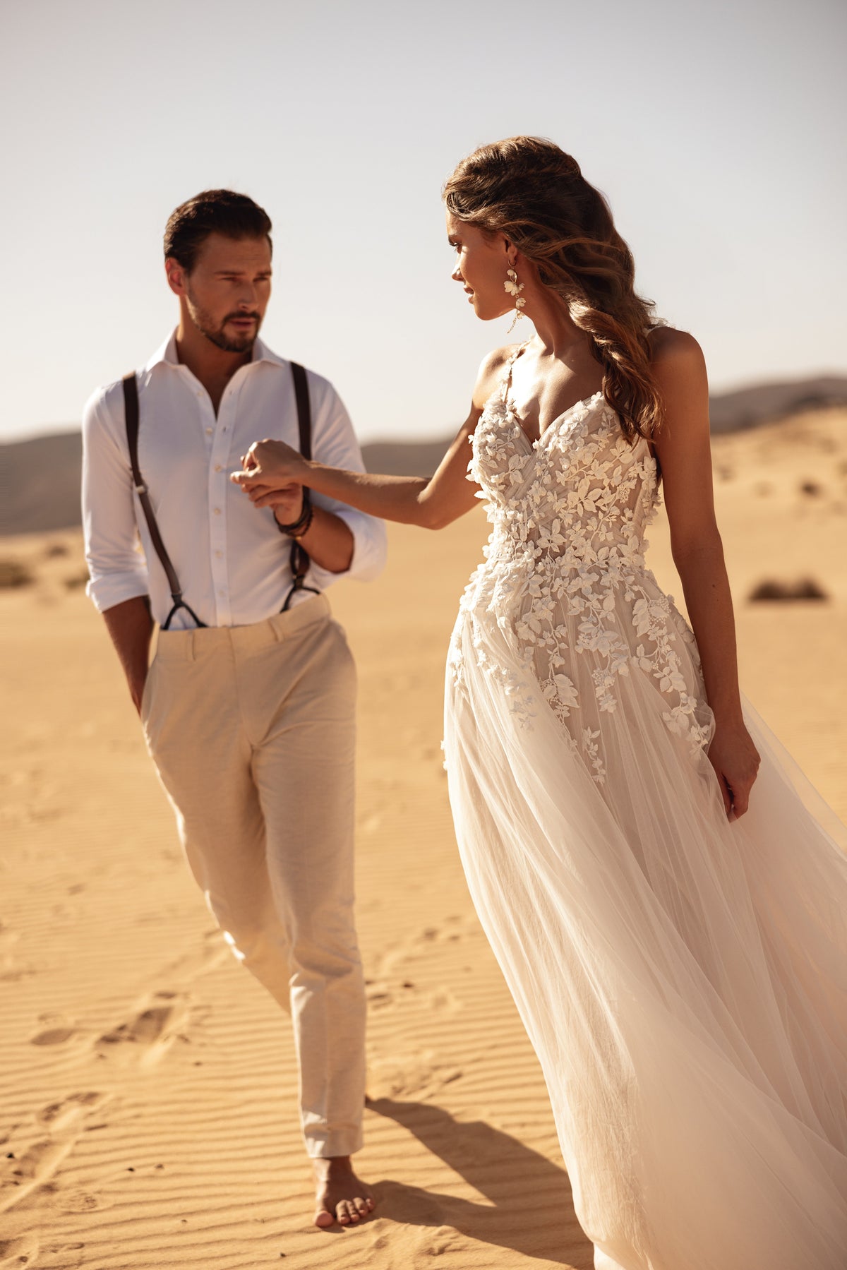 L’abito da sposa Aviva, con corpetto in pizzo floreale e spacco alto, interpreta la moda sposa contemporanea attraverso dettagli romantici.