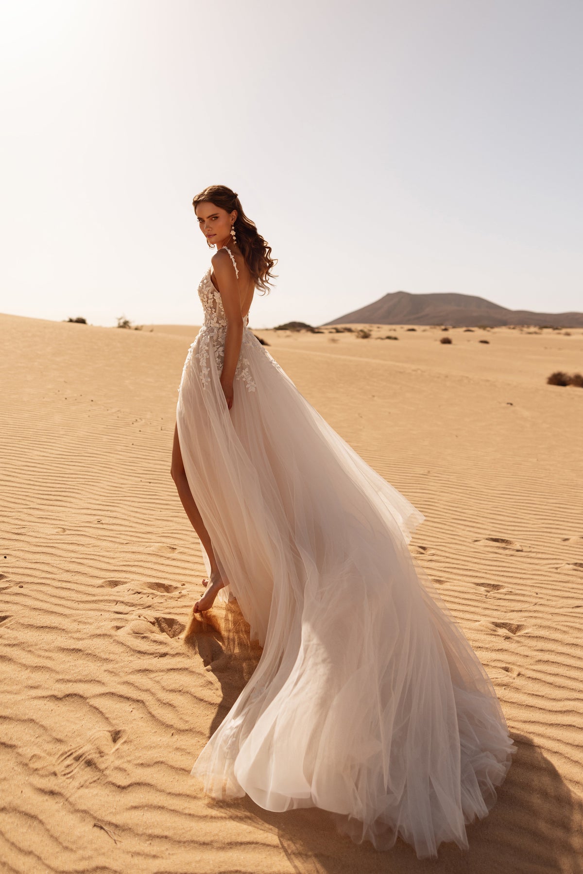 La gonna fluida in tulle e lo spacco anteriore dell’abito da sposa Aviva aggiungono movimento naturale e grazia.