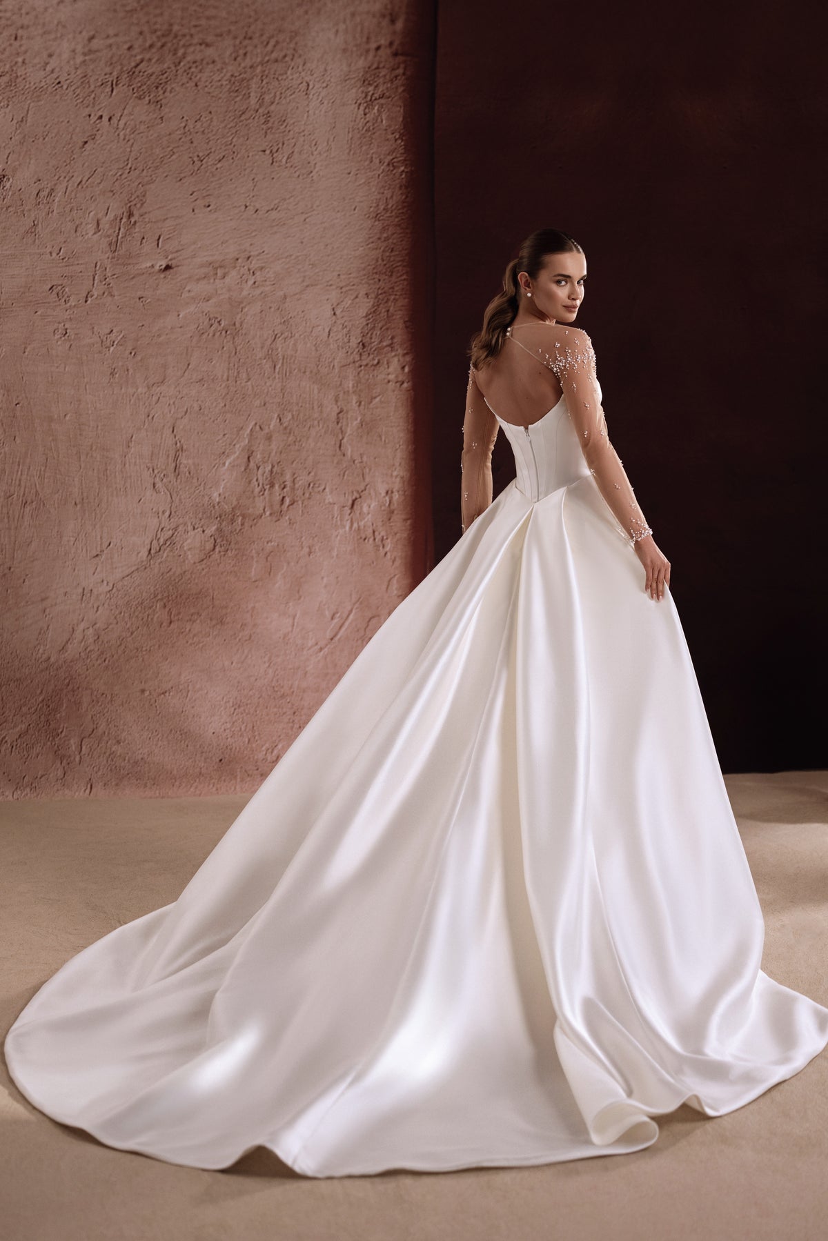 Il retro dell’abito da sposa Aylin in raso presenta una fila di bottoni, che valorizza la figura con raffinatezza.
