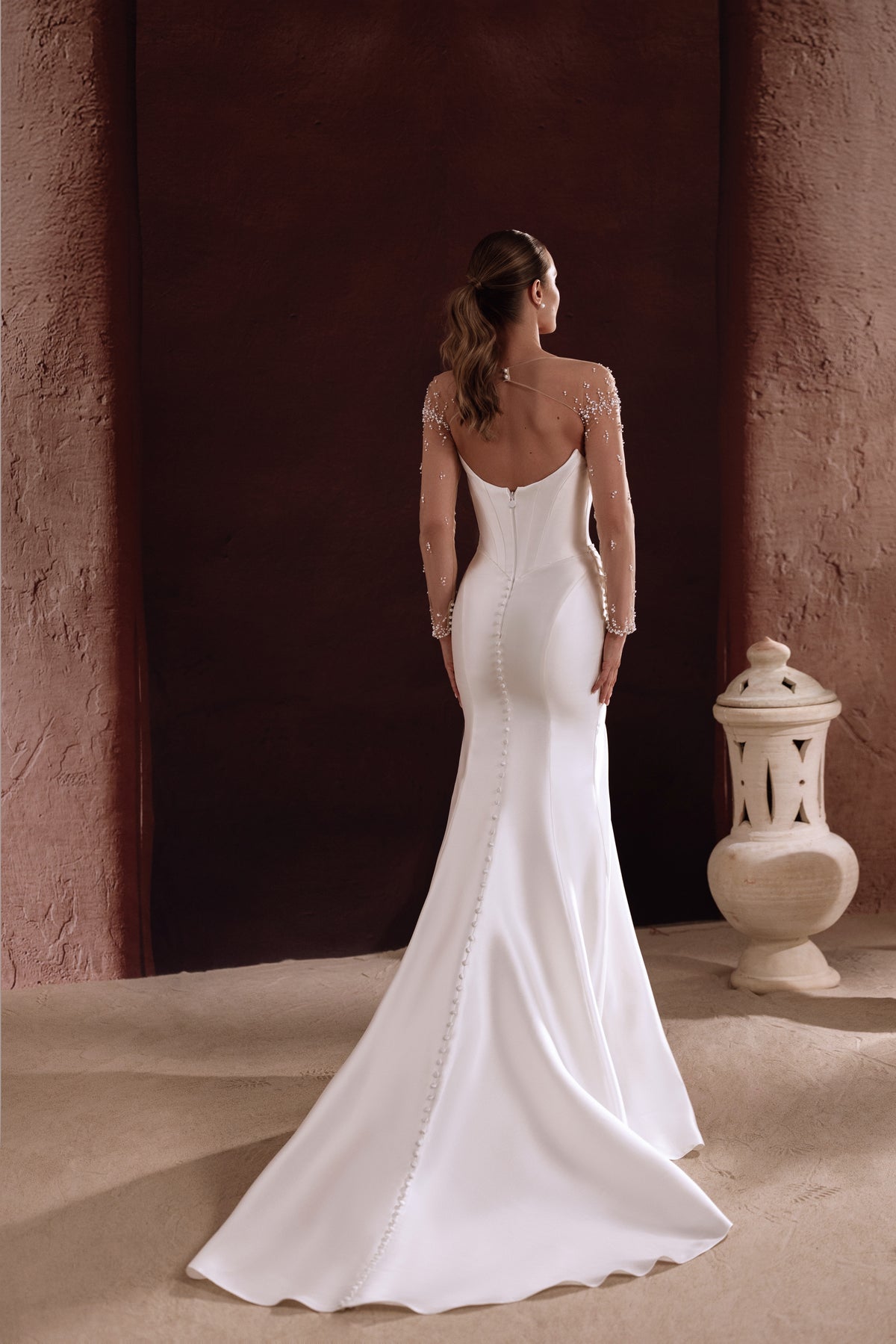 L’abito da sposa Aylin in raso, con corpetto strutturato e gonna ampia, esprime un’eleganza regale e preziosa.