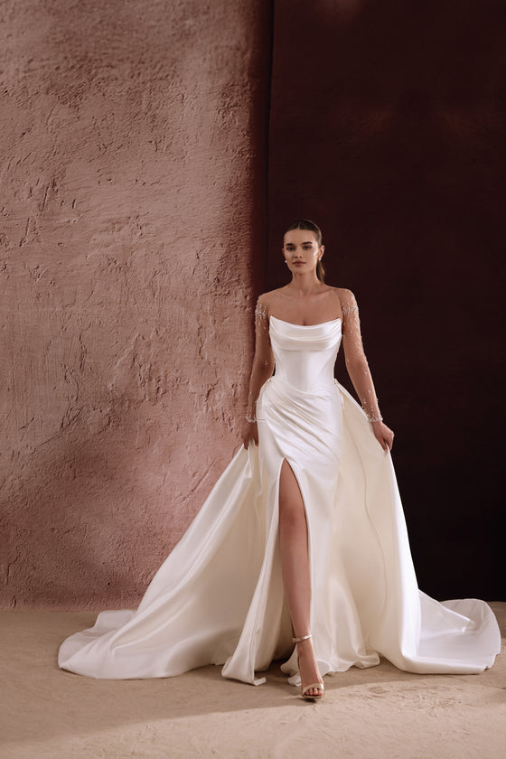 L’abito da sposa Aylin in raso, con spacco fino alla coscia e linea a sirena aderente, unisce glamour contemporaneo e grazia classica.
