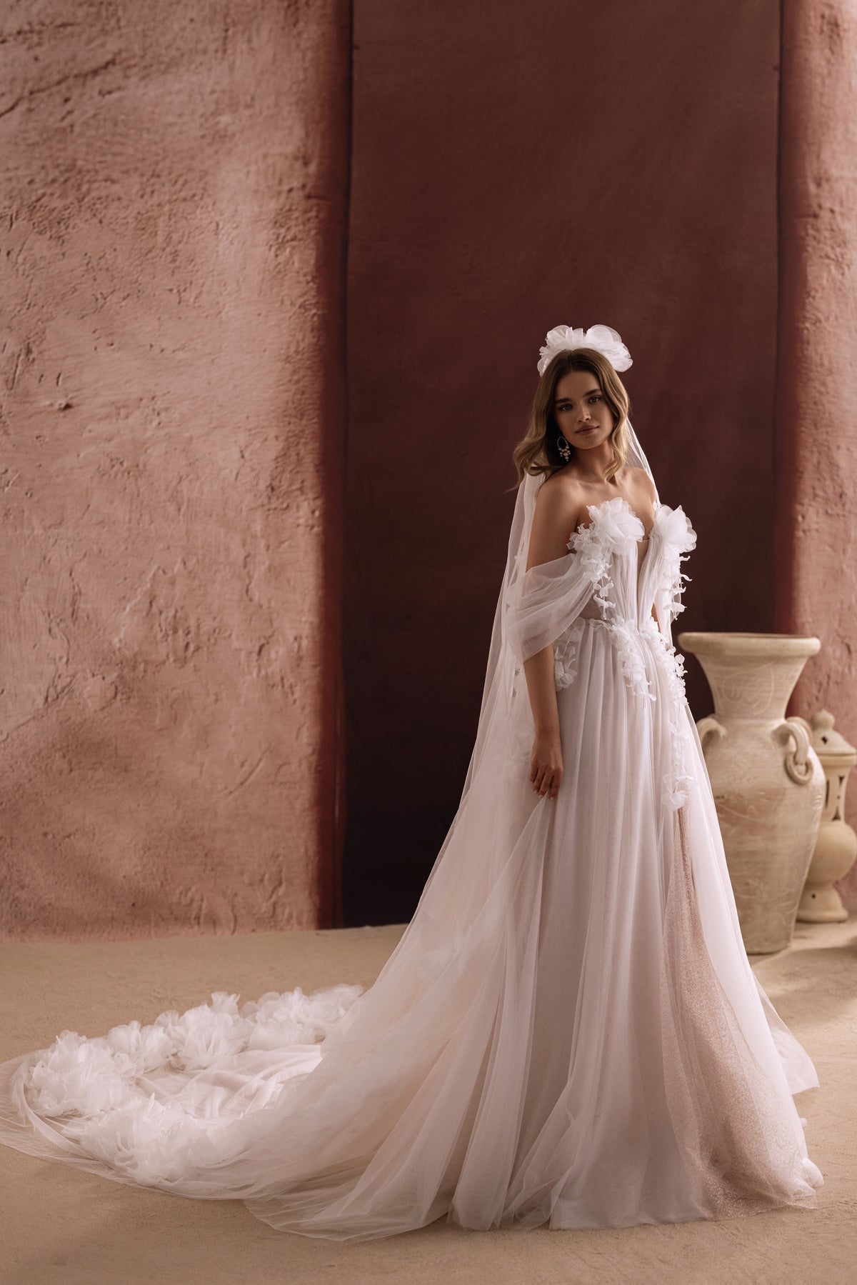 Il retro dell’abito da sposa Bella rivela un ampio strascico in tulle decorato con fiori 3D, per un look da fiaba.