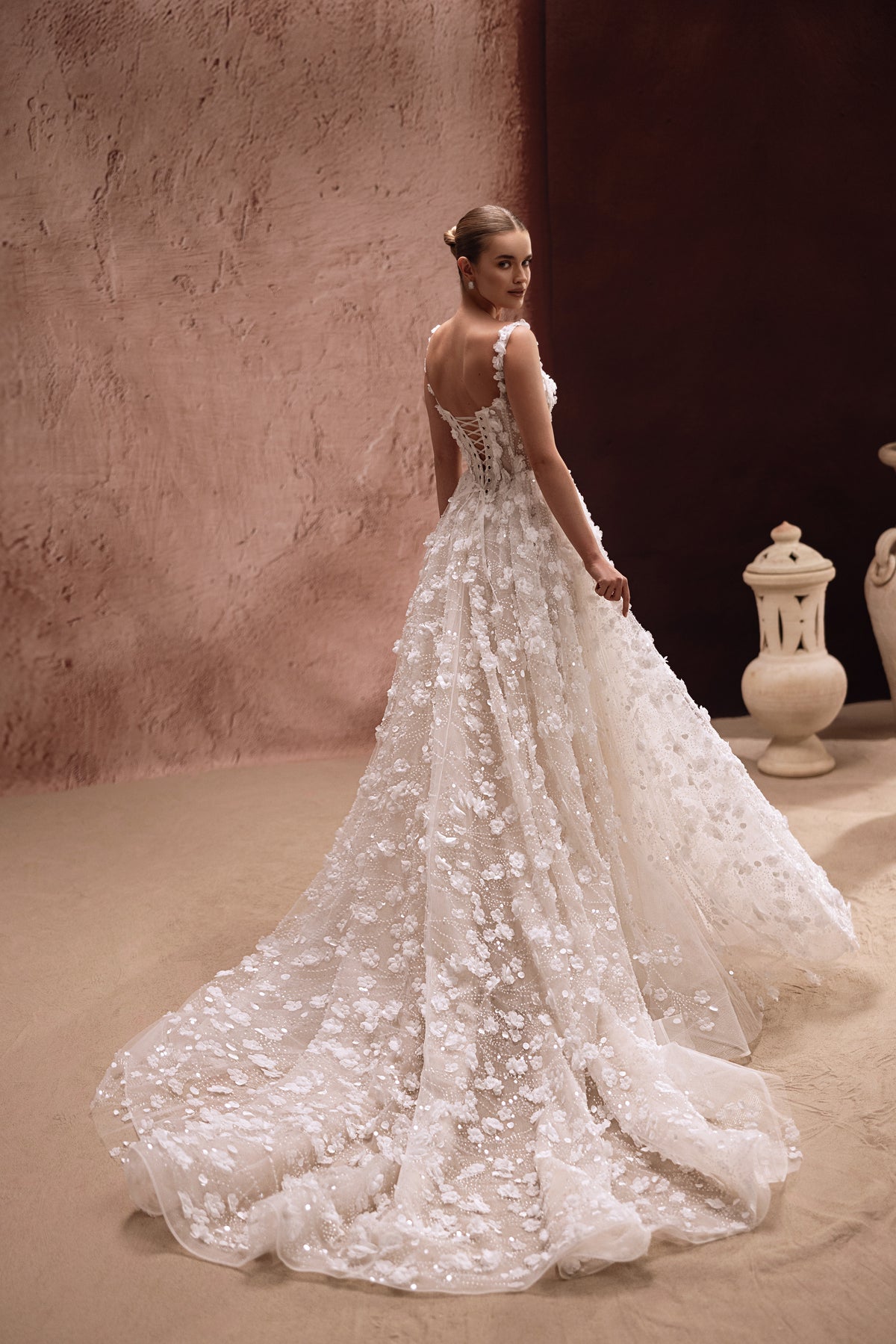 L’abito da sposa Cintra, con gonna voluminosa e decorazioni floreali 3D, crea un look glamour d’ispirazione regale.