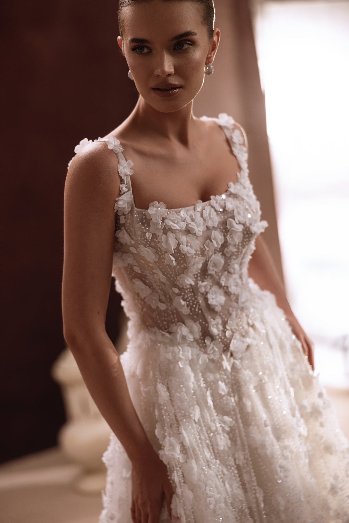 L’abito da sposa Cintra presenta un’allacciatura sulla schiena e uno strascico fluido, per una figura fiabesca e romantica.