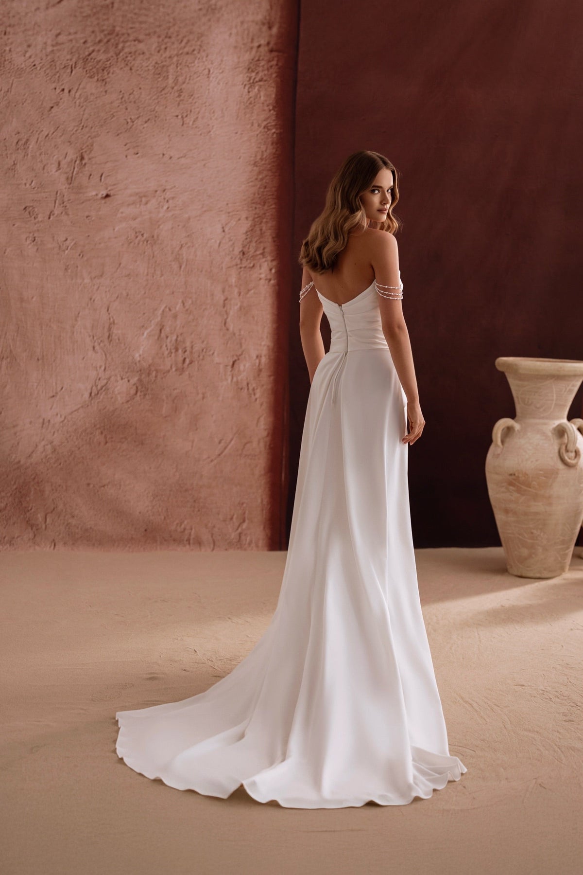 L’abito da sposa Eleonore, con scollo a spalle scoperte e morbide arricciature, esprime una bellezza senza tempo impreziosita di perle.