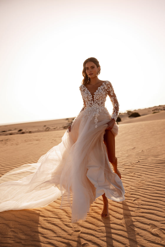L’abito da sposa Farida unisce un corpetto in pizzo effetto illusion a una gonna fluida in tulle, per una figura sognante nel giorno del matrimonio.