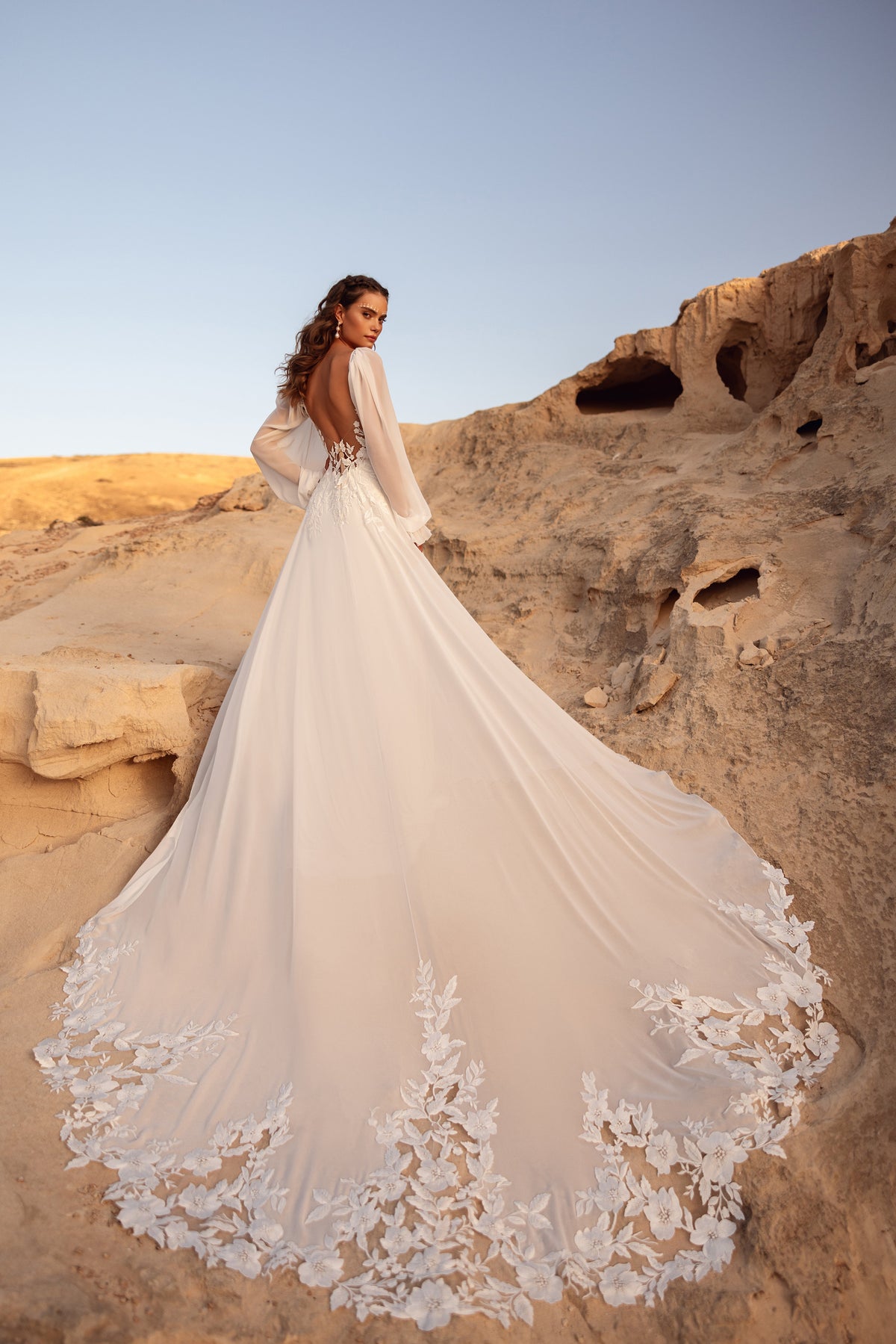 L’abito da sposa Judith, con schiena scoperta e dettagli in pizzo floreale, propone un look sensuale e raffinato.