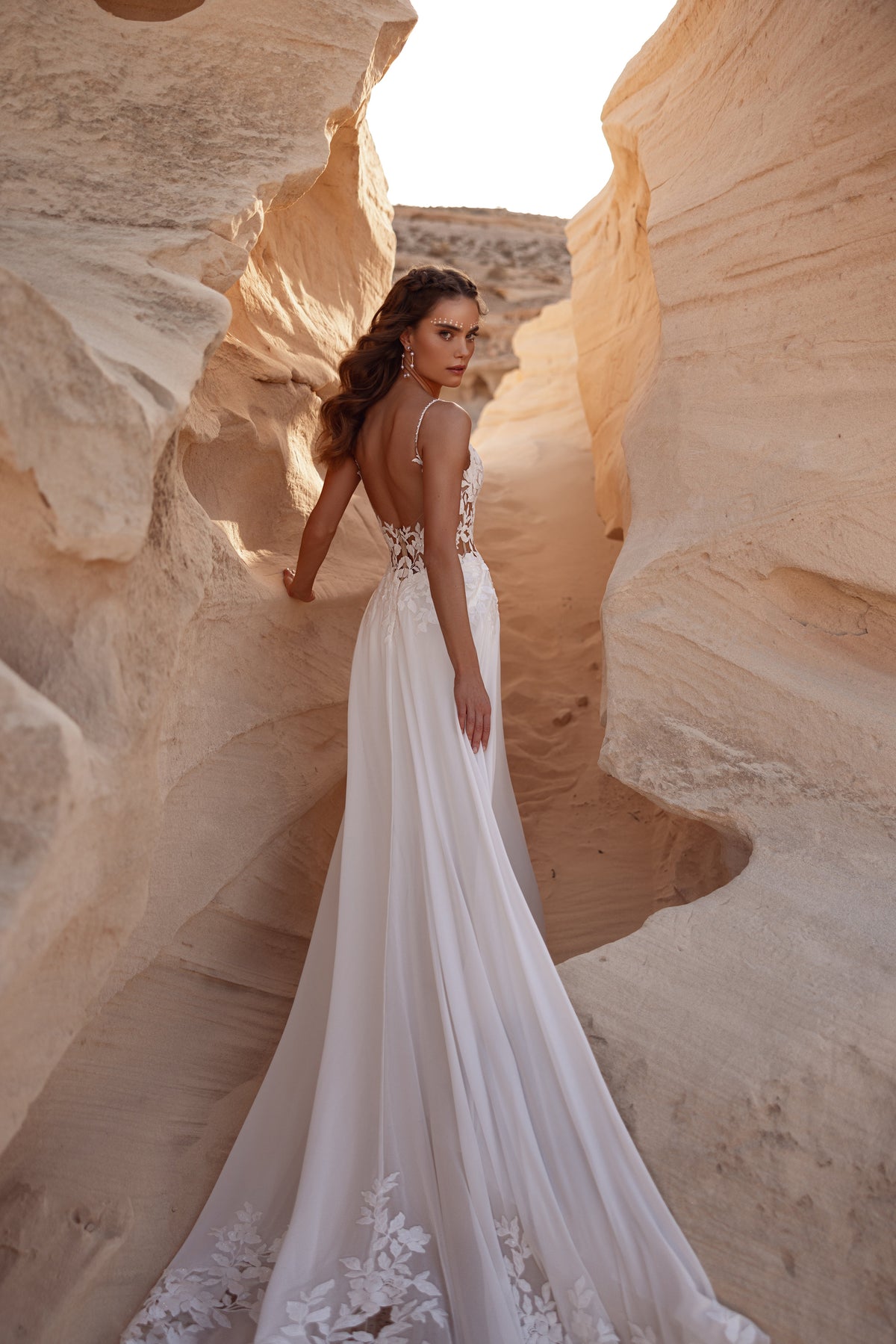 L’abito da sposa Malika, con schiena scoperta e morbida gonna a trapezio, unisce romanticismo boho e semplicità contemporanea.