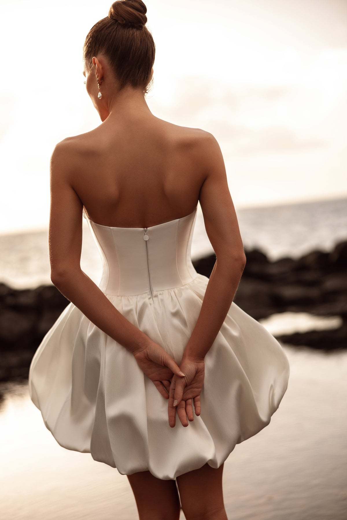 L’abito da sposa corto Martini, con schiena scoperta e gonna a palloncino, esprime eleganza contemporanea e un carattere giocoso.