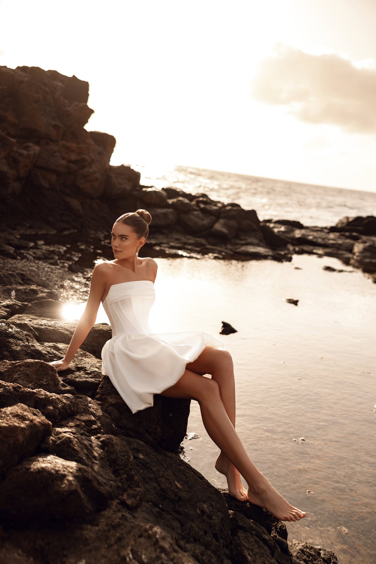 L’abito da sposa corto Martini, senza spalline e con corsetto aderente, sottolinea la vita e crea una figura moderna e sensuale.