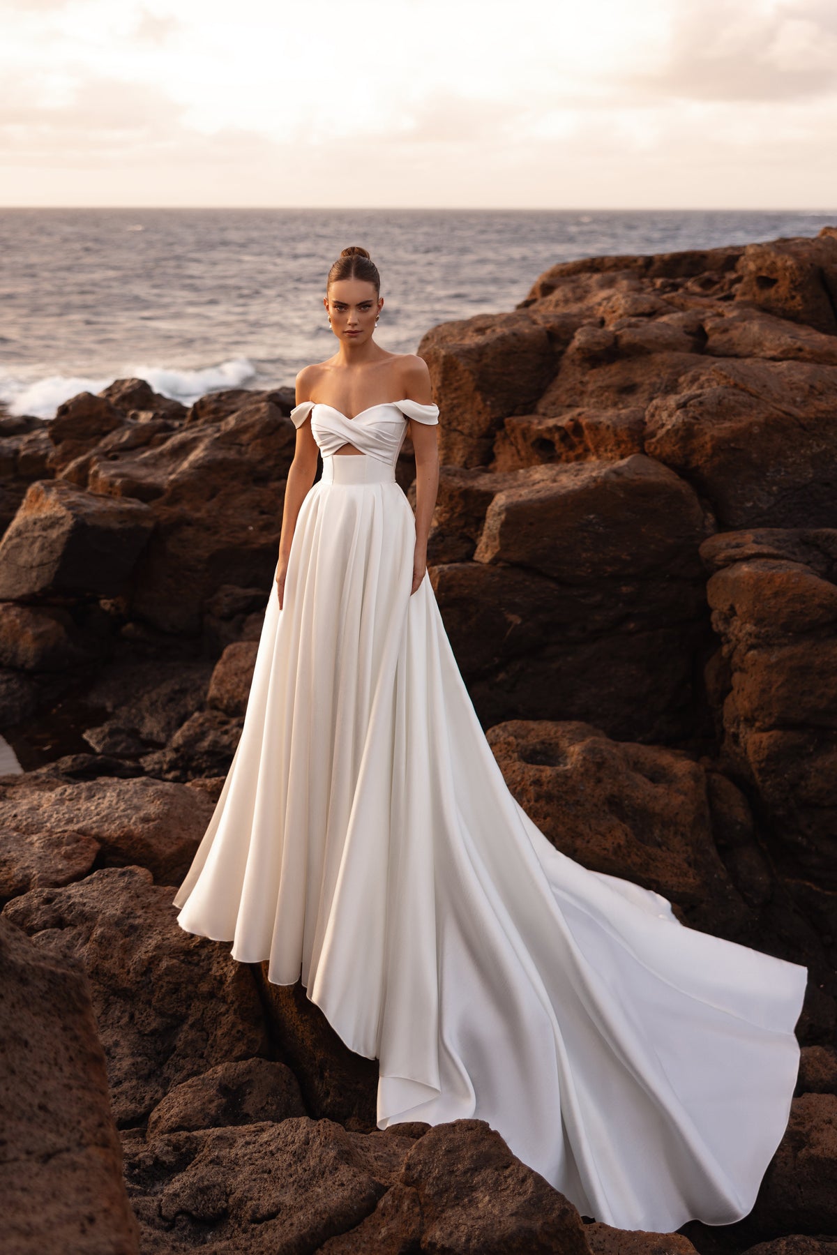 L’abito da sposa Mellisandre a principessa, con spalle scoperte e strascico fluido, propone un look romantico e regale.