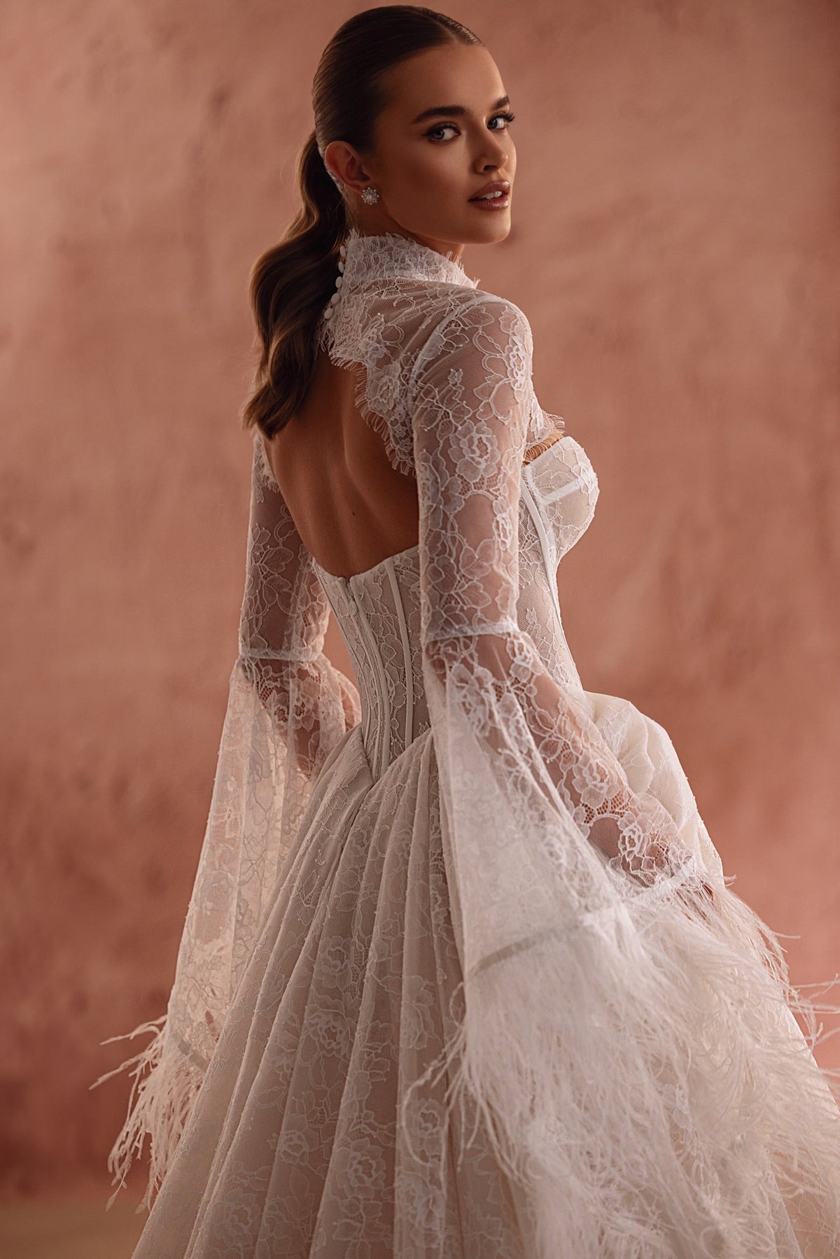Il bolero da sposa Michelle in pizzo, con maniche lunghe e stile d’alta moda, aggiunge un accento personale al look.