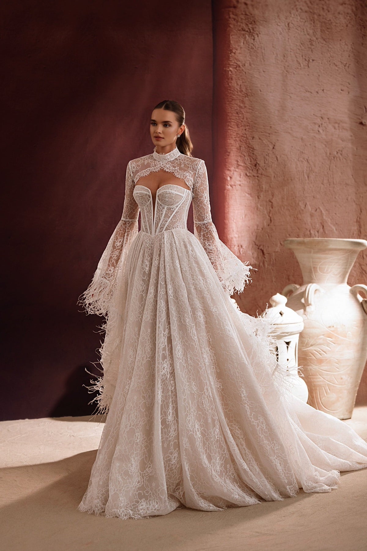Il bolero da sposa Michelle in pizzo, con maniche lunghe e scollo alto, aggiunge eleganza e raffinatezza all’abito.