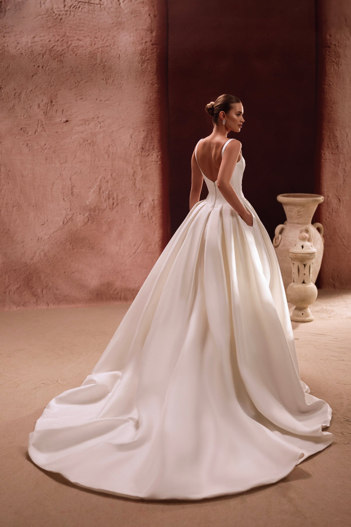 L’abito da sposa Nicolette, con ampio strascico cappella, esprime eleganza regale e glamour senza tempo.