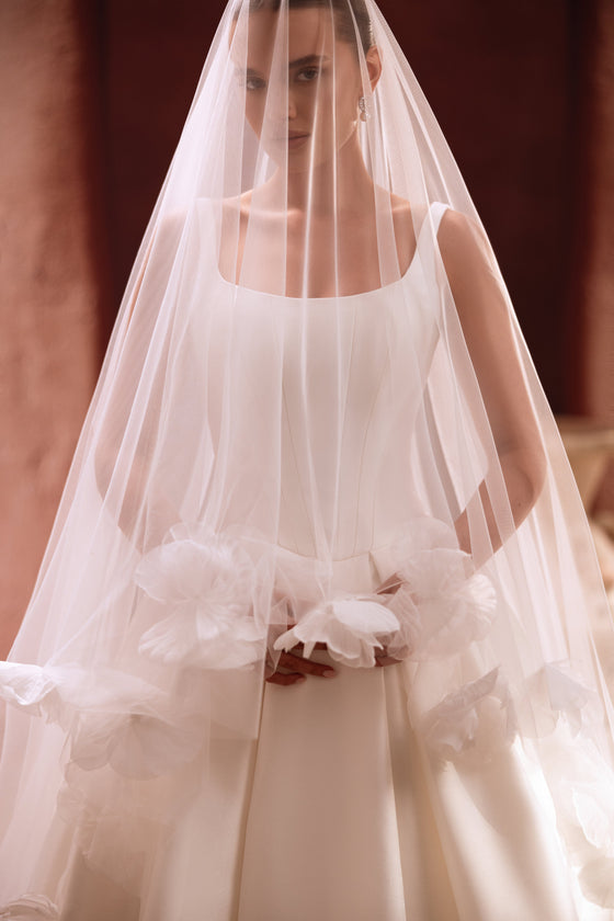Velo da sposa Nicolette con dettagli floreali applicati a mano, che valorizza un abito essenziale.